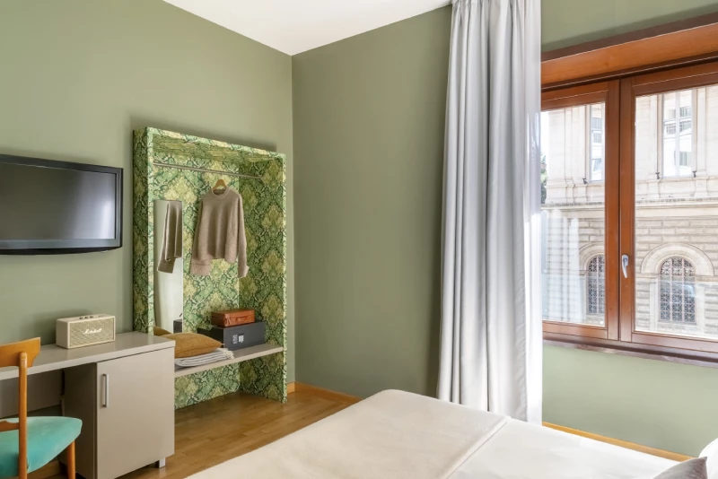 Standard room with desk, wall-mounted TV and open wardrobe, modern design with urban view in Monti district Rome - Monti First, BZAR hotels in Rome